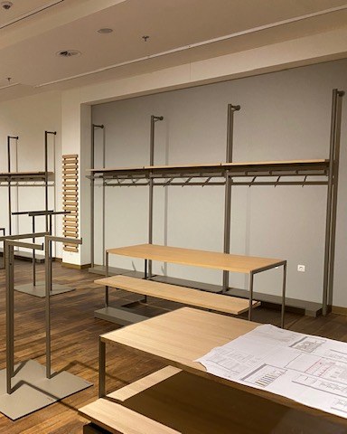Ladeneinrichtung mit Regalen und Tischen in einem Verkaufsraum — Symbolbild